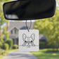 Car air freshener with a dog illustration hanging from a car's rearview mirror.