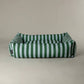 Green and blue scruffs striped pet bed on a beige background