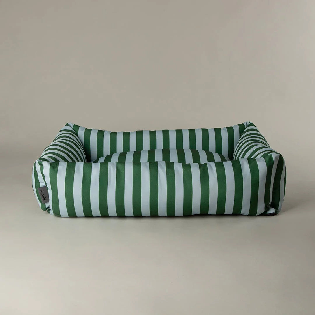 Green and blue scruffs striped pet bed on a beige background