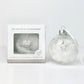 Pet memorial glass bauble with paw charm and packaging on a light gray background