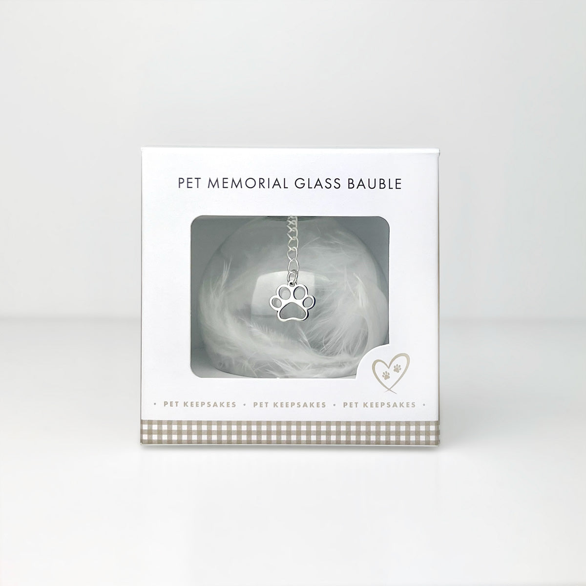 Pet memorial glass bauble in packaging with paw print design on a white background
