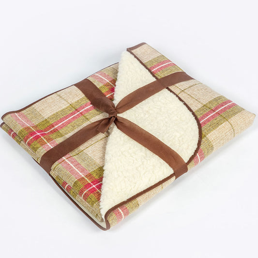 Folded plaid blanket with a brown ribbon on a white background