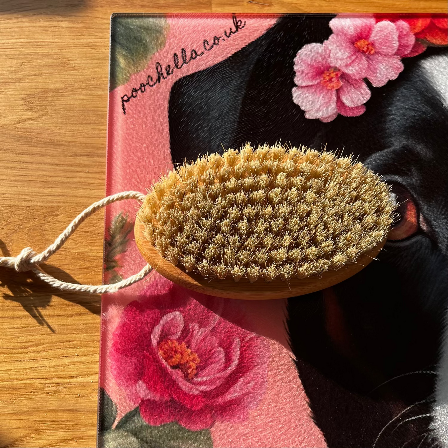 dog grooming brush with a floral design on a wooden surface