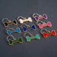 Colorful bone-shaped pet tags with 'BAILEY' engraved on a dark background