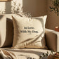 Beige pillow with 'In Love. With My Dog.' text on a beige couch with plants in the background