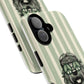 A close-up of a phone case with a mint green and cream vertical stripe pattern, featuring a black-and-white illustration of a dog wearing peace sign sunglasses. The case has a black camera bumper and side button covers, shown against a plain white background.
