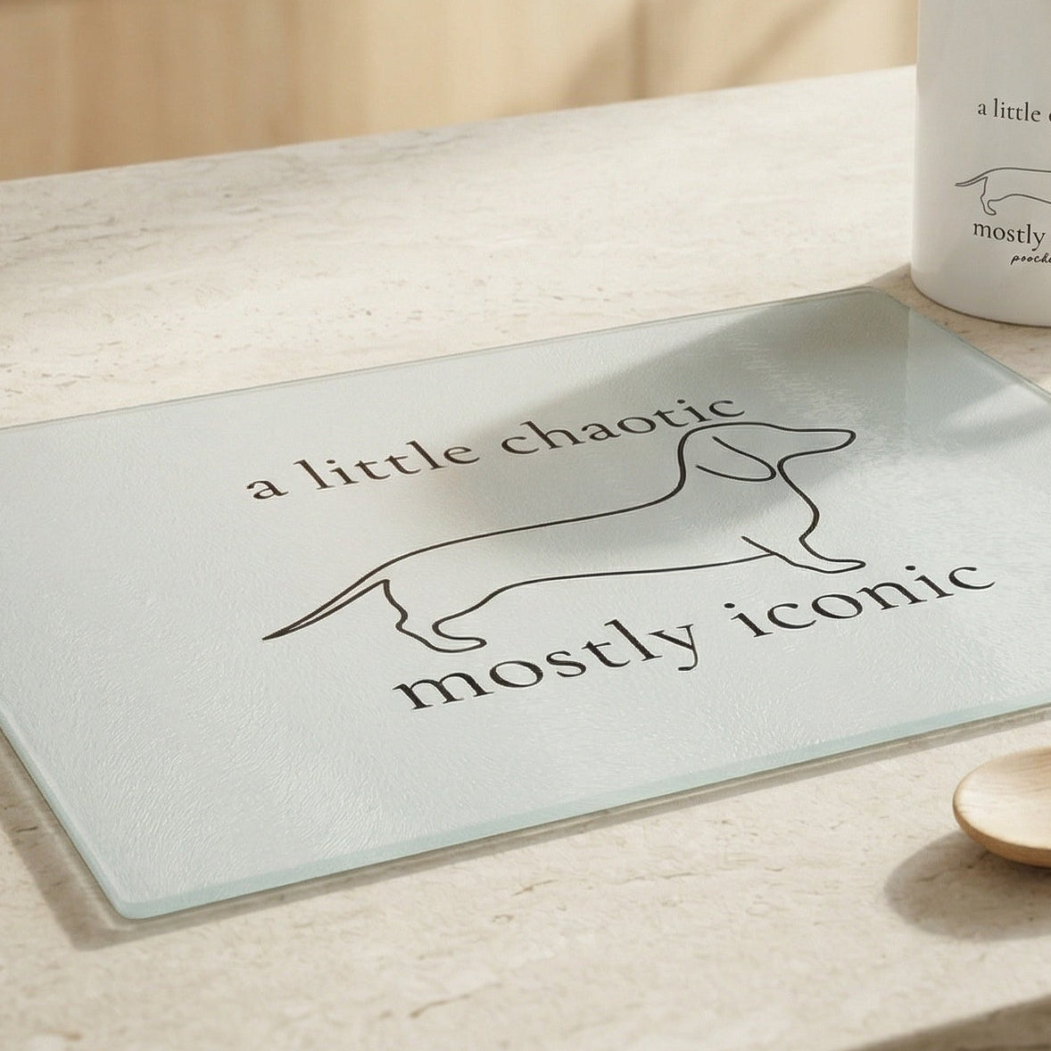 Glass board with dog illustration and text on a wooden surface