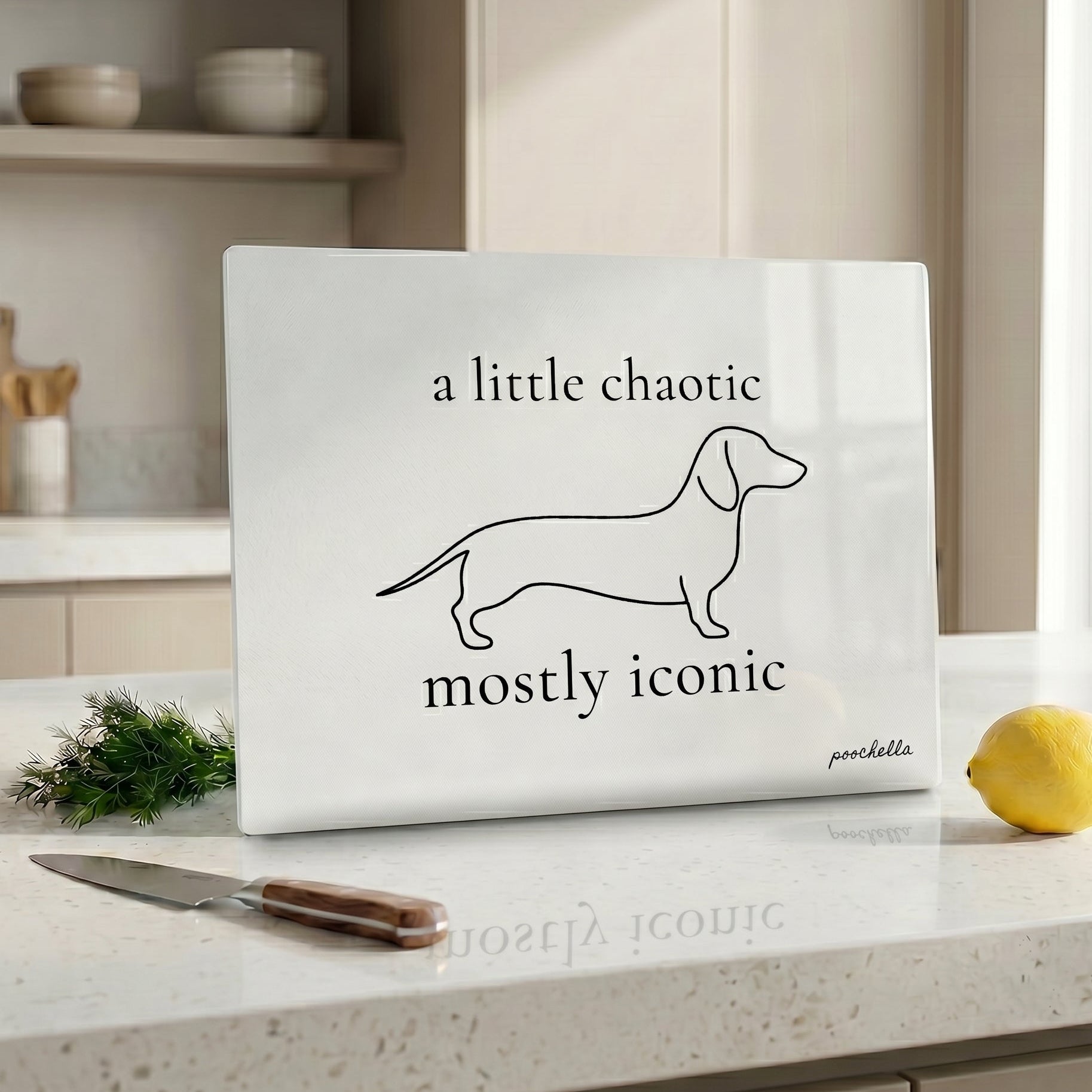 Glass cutting board with dachshund design and text on a kitchen counter