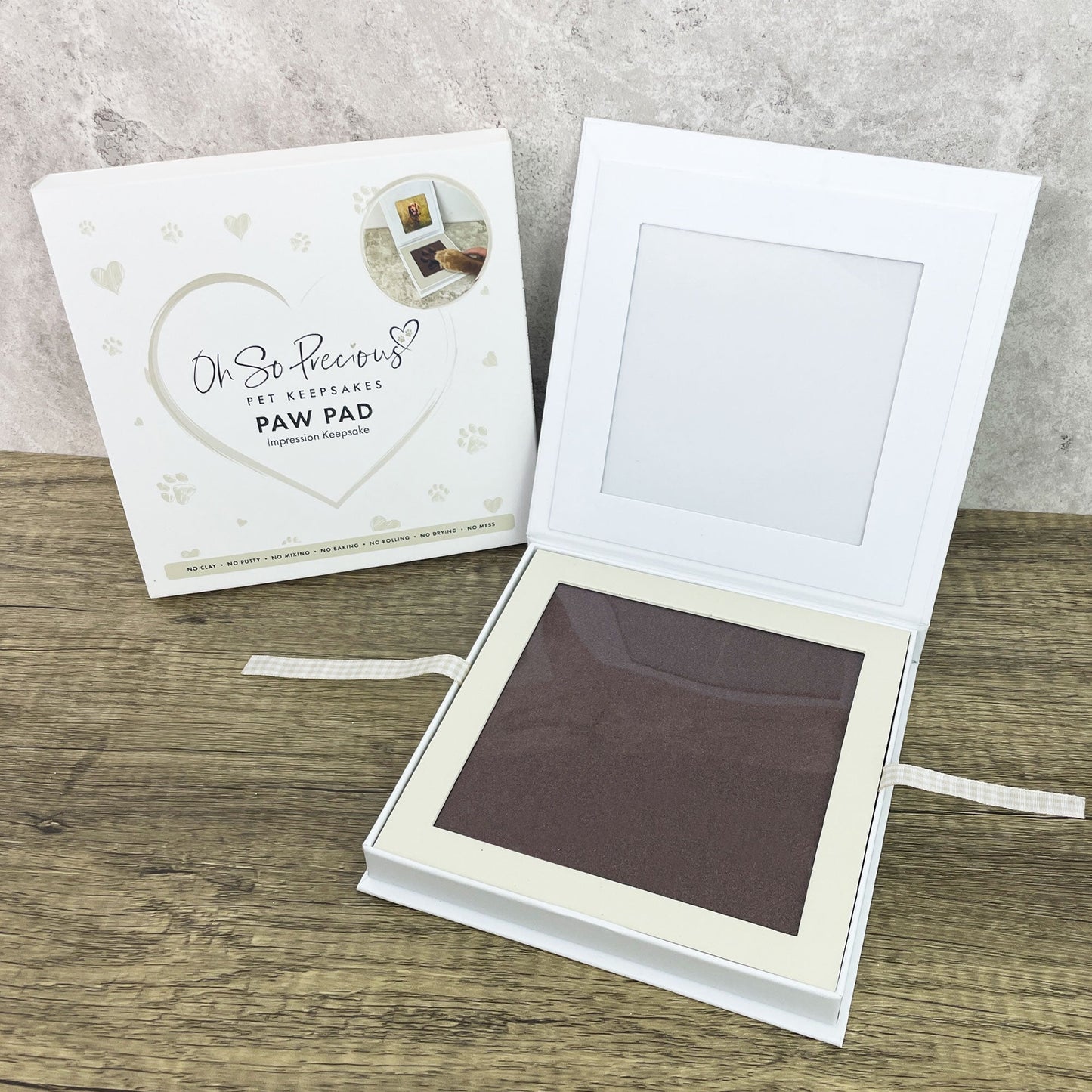 Pet memorial paw pad with packaging on a wooden surface