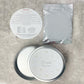Pet paw print kit with a round container, packaging, and instructions on a gray surface.