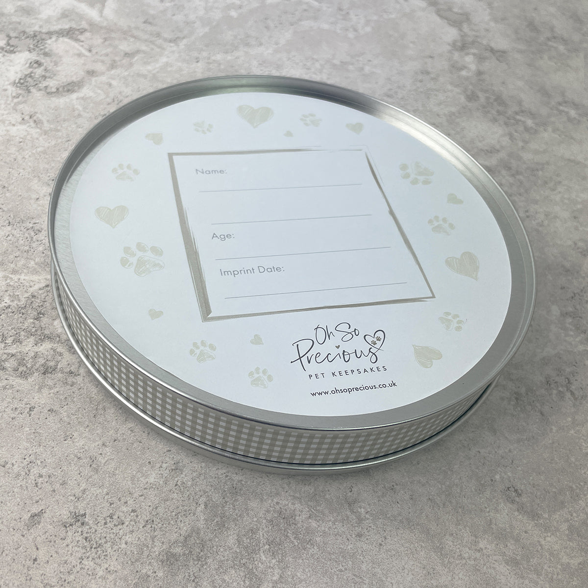 Round metal container with a label on a gray surface