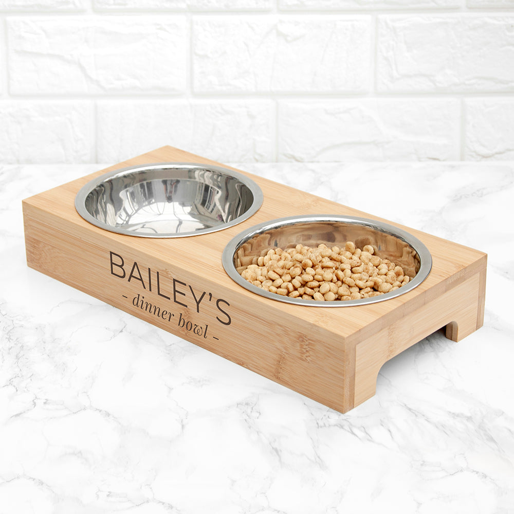 Pet food bowl set with wooden base and 'BAILEY'S' engraving on a white background
