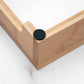 Wooden frame corner with a black circular object on a white background