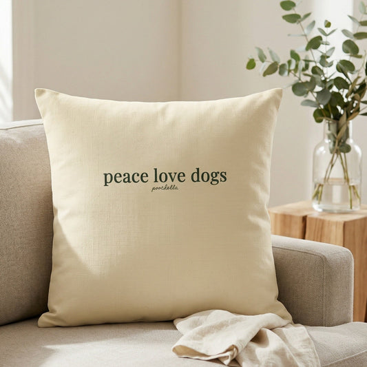 Beige pillow with 'peace love dogs' text on a beige sofa in a living room setting.