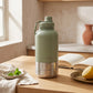 a sage green travel water bottle with small poochella branding