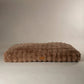 Brown textured pet bed mattress on a beige background