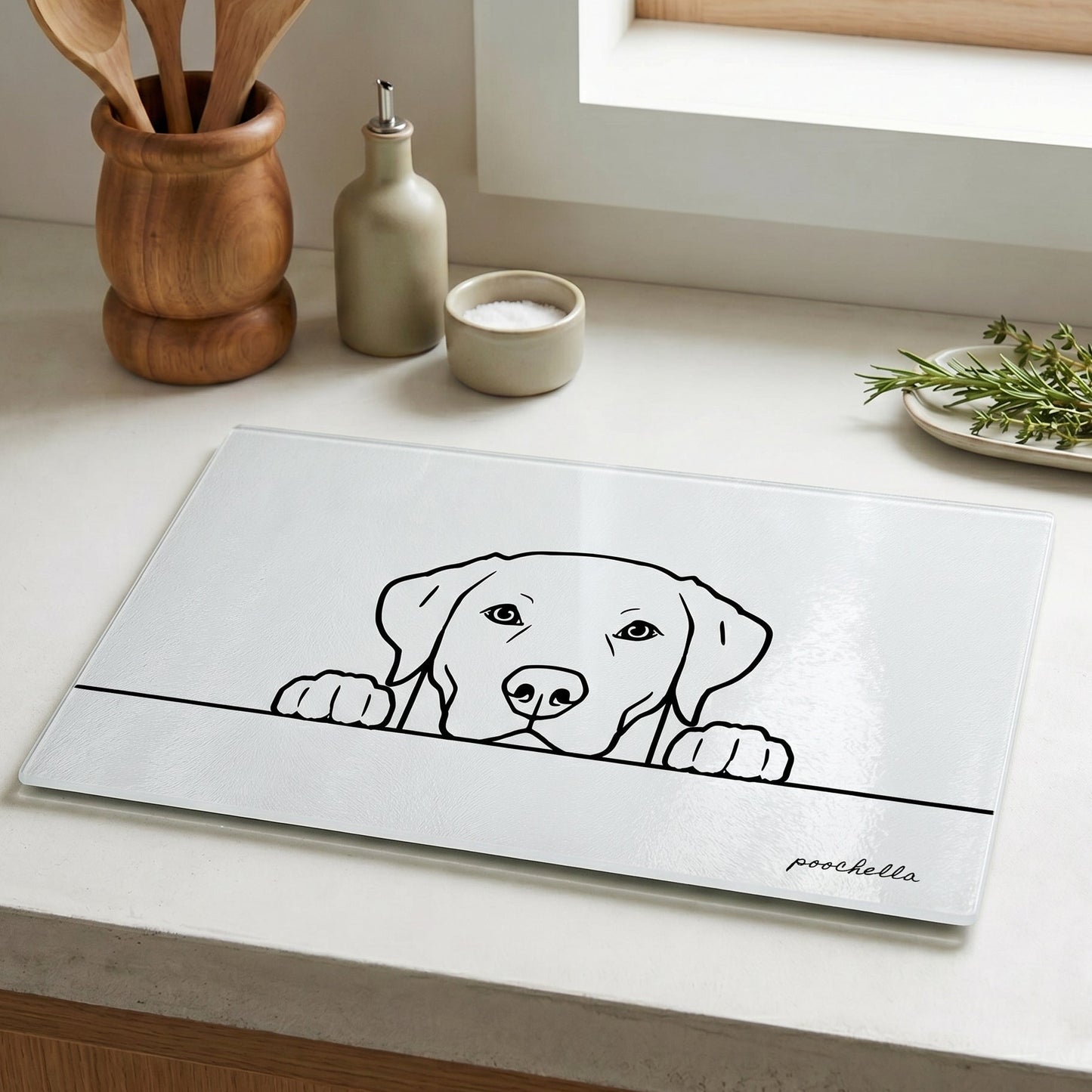 Kitchen counter with a placemat featuring a dog illustration and 'poochella' branding.