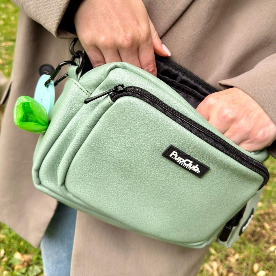 Person holding a green bag with a brand logo outdoors