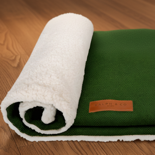 Green and white textured blanket with a brand label on a wood background