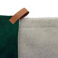 Green fabric with a brown leather strap and white textured material on a white background
