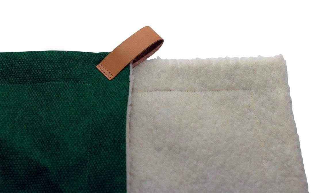 Green fabric with a brown leather strap and white textured material on a white background