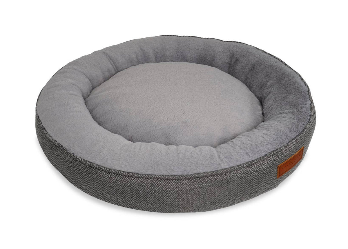 Gray pet bed with a textured exterior and plush interior on a white background
