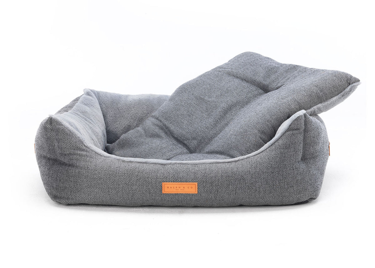Gray pet bed with a visible brand logo on a white background