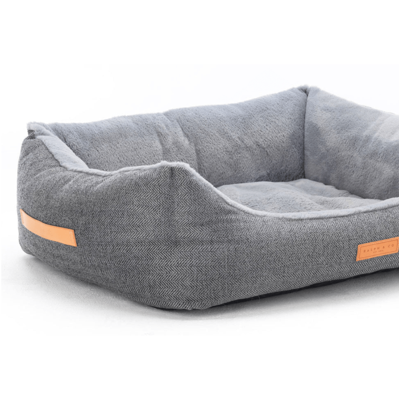 Gray pet bed with orange accents on a white background