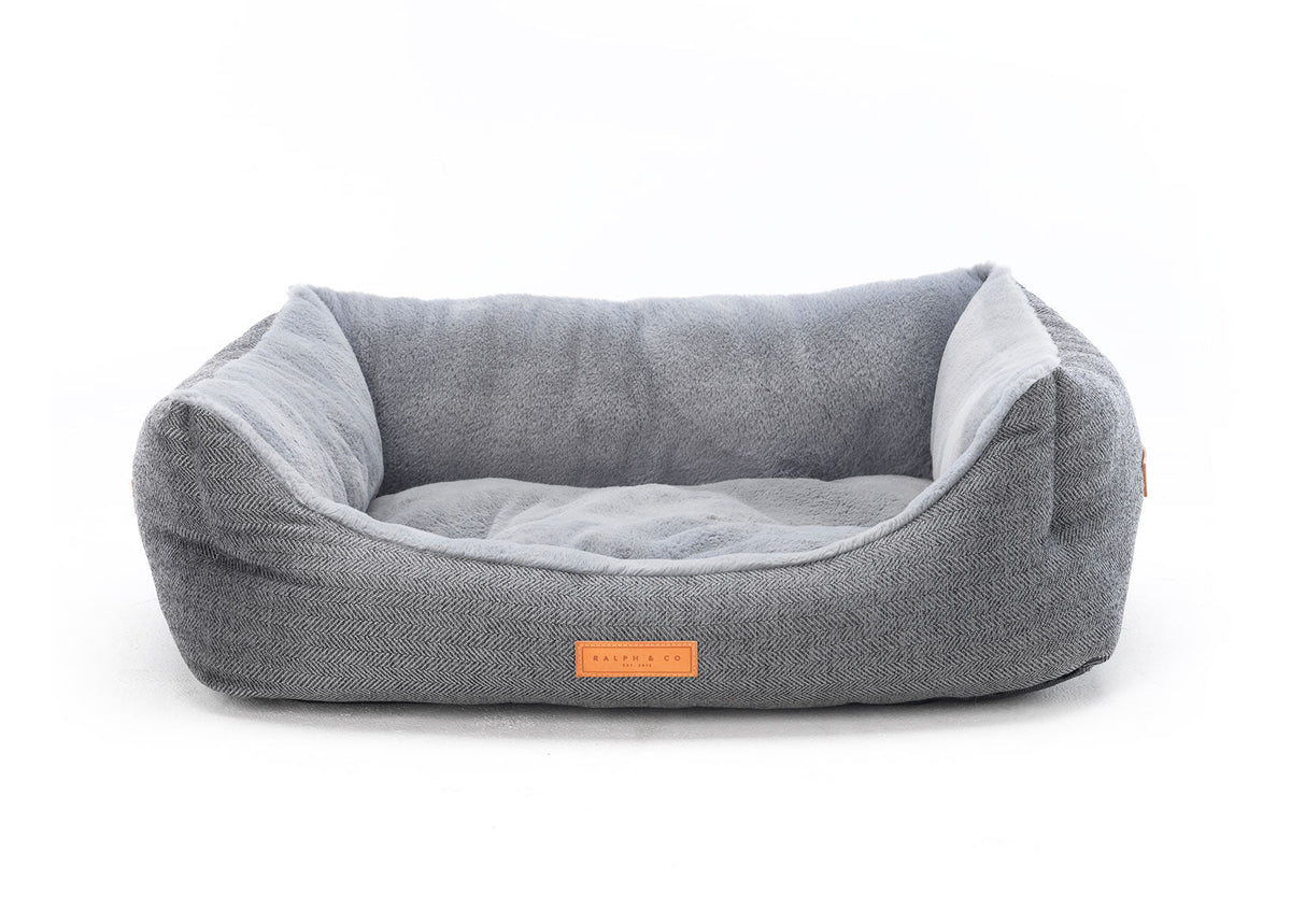 Gray pet bed with a visible brand logo on a white background