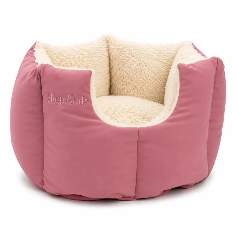 Pink pet bed with beige interior on a white background