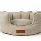 Beige pet bed with a brown label on a white background