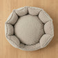 Round beige pet bed on a white background