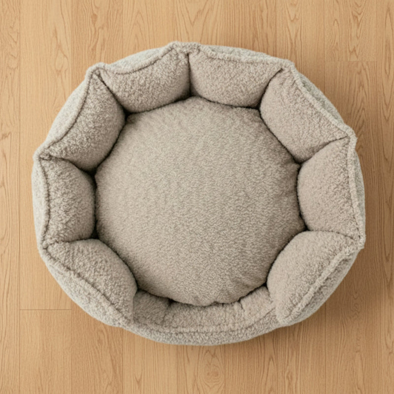 Round beige pet bed on a white background