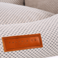 Textured fabric surface with a brown leather label displaying 'Ralph & Co' on a blurred background.