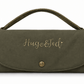 An olive green suede clutch bag with a top handle, featuring the personalized name 'Hugo&Ted' embroidered in gold on the front flap, set against a plain white background.