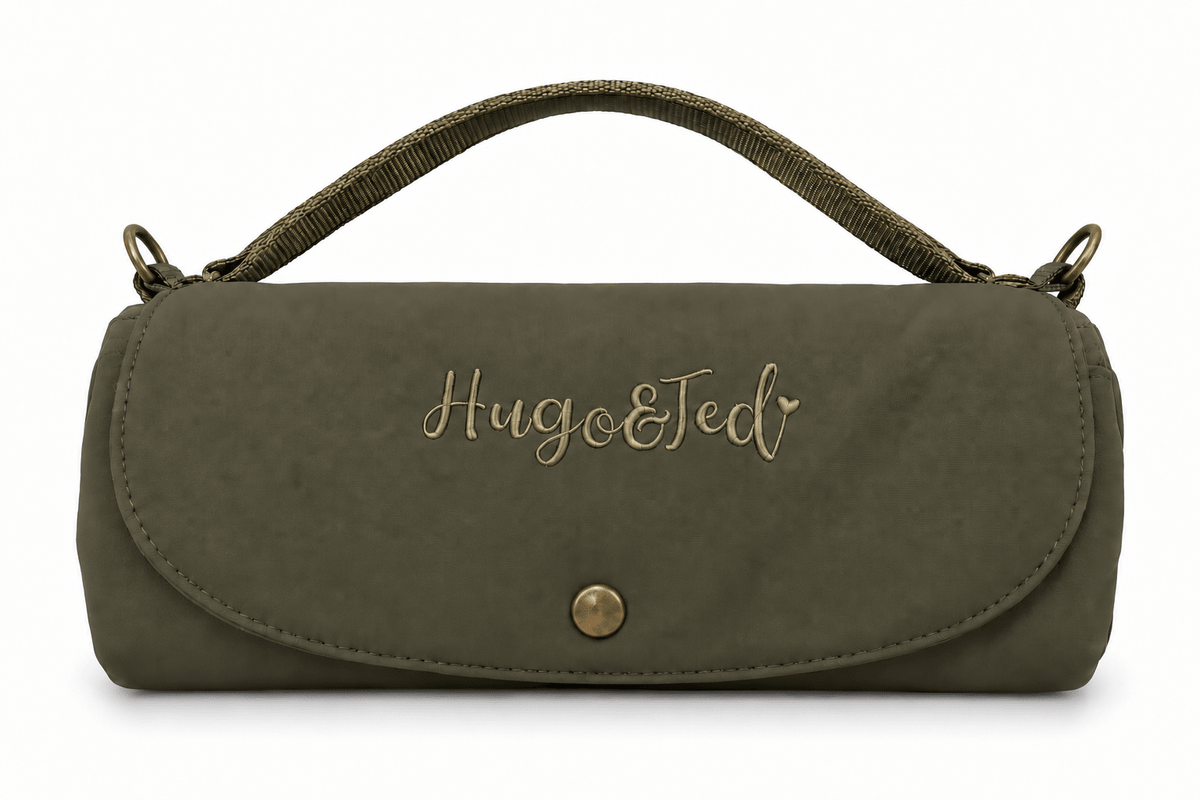 An olive green suede clutch bag with a top handle, featuring the personalized name 'Hugo&Ted' embroidered in gold on the front flap, set against a plain white background.