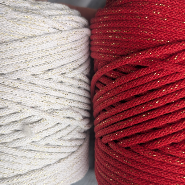 Two spools of yarn, one white and one red, with glittery threads.