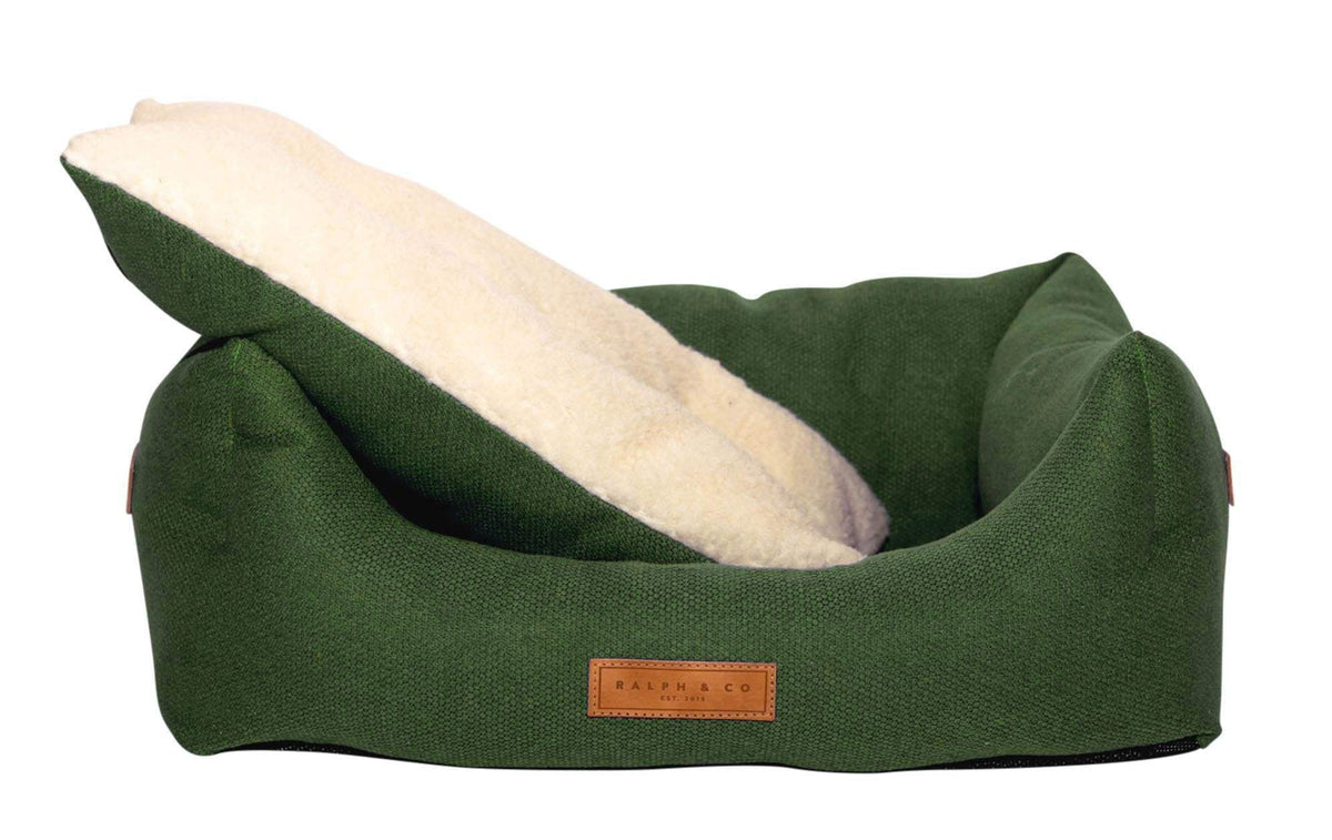 Green pet bed with a white cushion on a white background