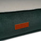 Close up of Green fabric dog bed surface with a brown leather label featuring 'Ralph & Co' branding.