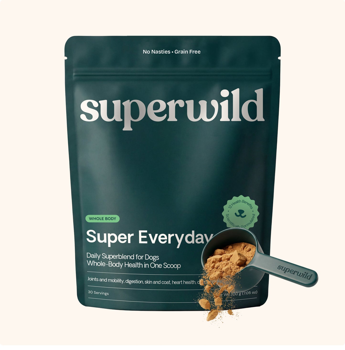 A dark teal stand-up pouch of superwild Super Everyday dog supplement, shown on a light beige background with a scoop of the brown powder in front.