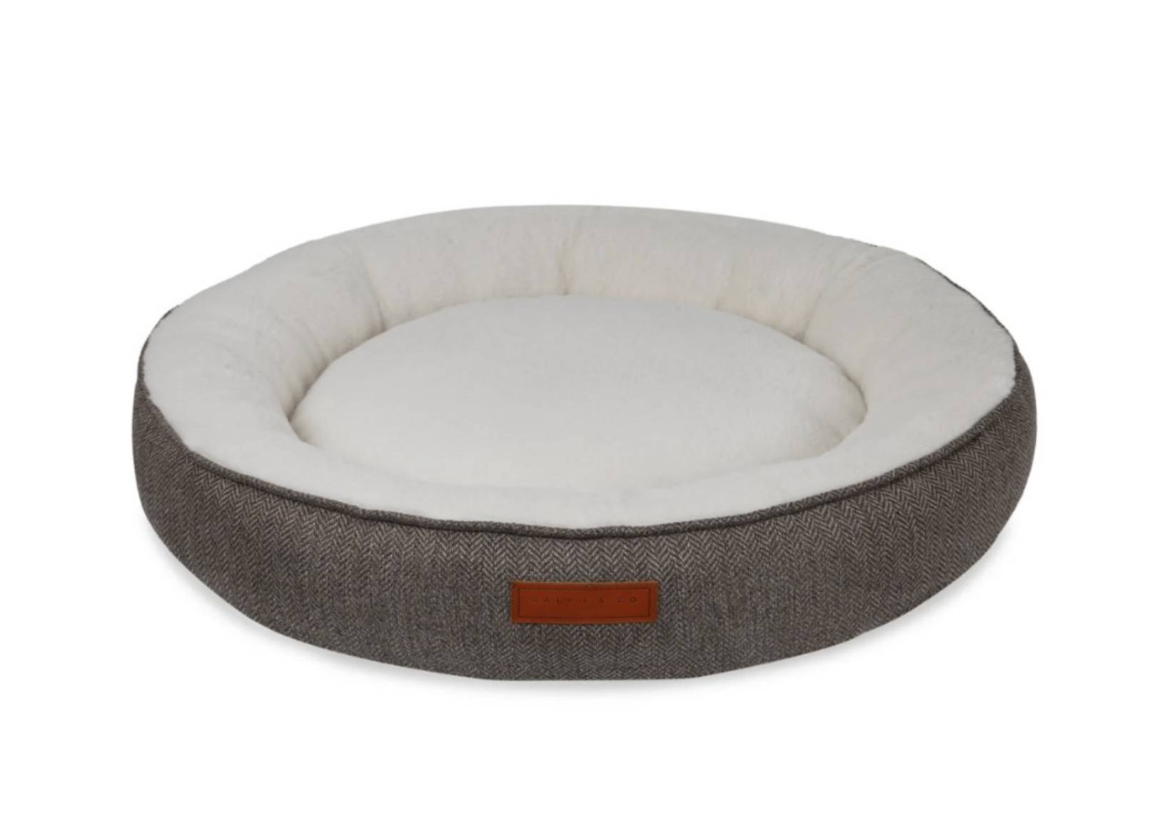Round pet bed with gray exterior and white interior on a white background