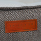 Close-up of a textured fabric surface with a brown leather label displaying 'RALPH & CO' branding.